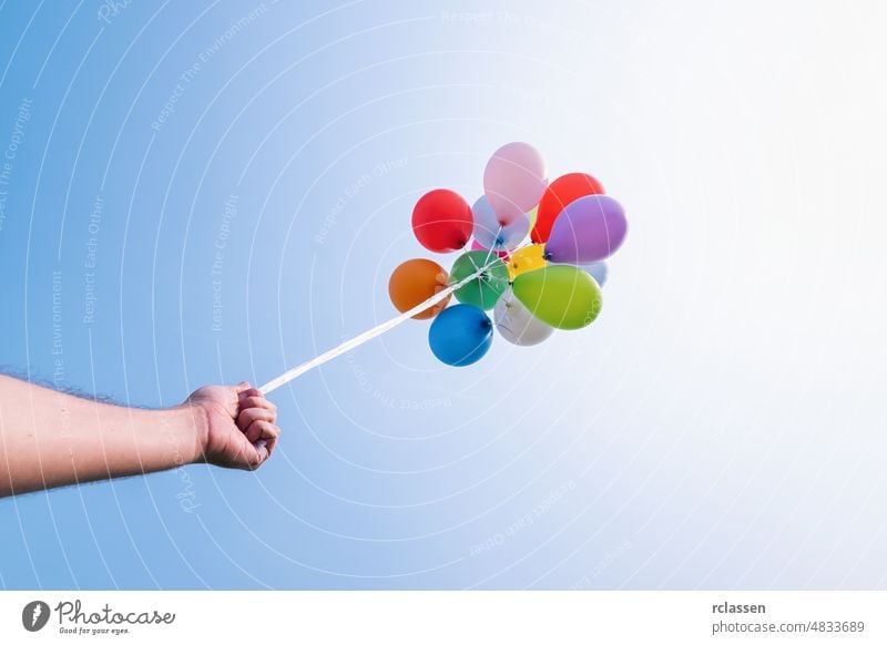 Hand hält Bunte Luftballons gegen blauen Himmel Ballon Geburtstag Party Feier farbenfroh Latex Träume Air Jahrmarkt Haufen feiern Kindheit Farbe Konzept kreativ