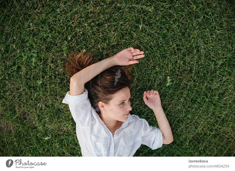 Aufnahme einer auf grünem Gras liegenden Frau oben Erwachsener Kaukasier Tagträumen Garten Mädchen Hände Glück Freizeit Lifestyle Lügen Wiese Natur im Freien