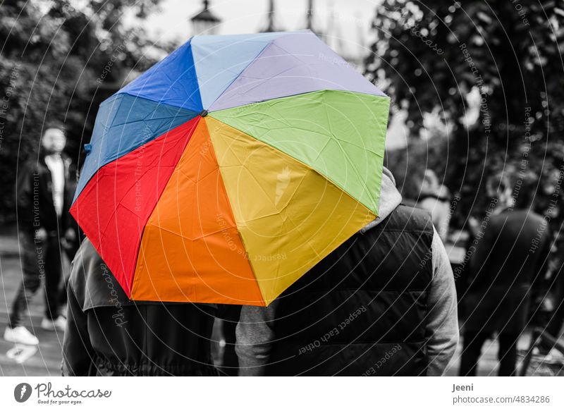 Zwei unter dem bunten Regenschirm des Lebens regenbogenfarben Wetter Schutz nass farbig Menschen Schirm schwarzweiß gegensätzlich besonders anders Gruppe Paar