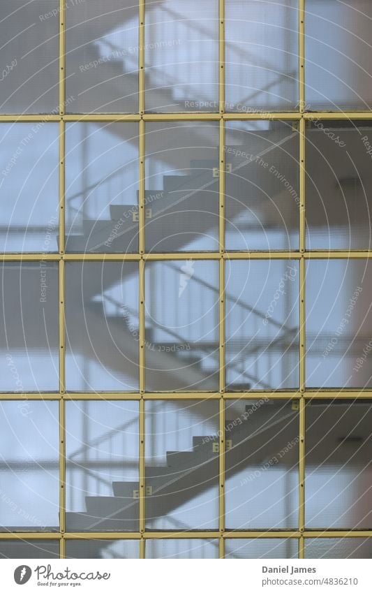 Treppe durch gelbes Gitter Treppenhaus Architektur mehrstöckig Raster Muster Wiederholung Geländer Wendeltreppe intern Glasfassade Strukturlinien Gebäude