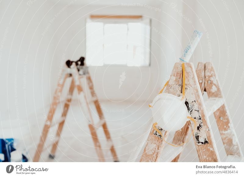 Leitern und Malerwerkzeuge auf weißem Raum auf der Baustelle. Wände streichen. Heimwerken Werk Renovierung heimwärts Laufmasche Haus Farben Innenbereich Rolle