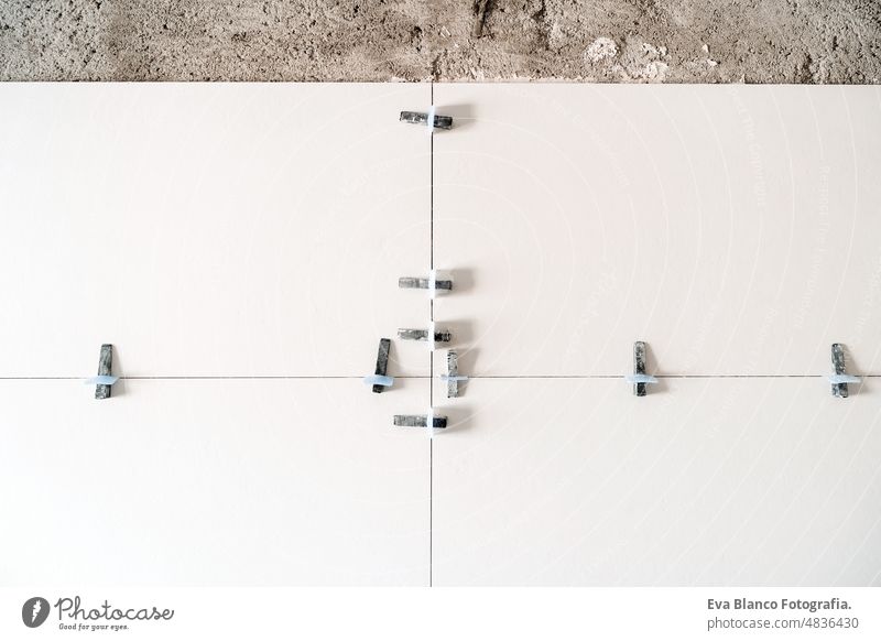 baustelle. weiße moderne fliesen im bad mit trennwand und nivellierung während der arbeiten. Renovierung eines Hauses Nivellierung Standort Innenbereich
