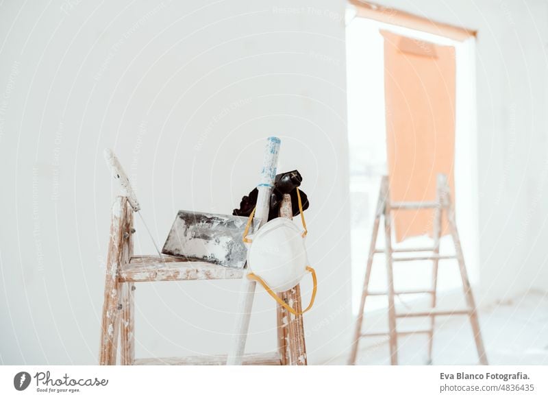 Leitern und Werkzeuge in einem weißen Raum auf einer Baustelle. Wände streichen. Heimwerken, Renovierung heimwärts Laufmasche Haus Farben Innenbereich Rolle