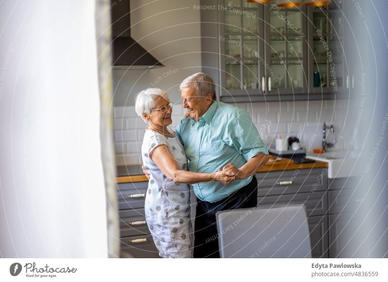 Älteres Paar tanzt in seiner Küche älterer Erwachsener gealtert Porträt Person lässig Freizeit Lifestyle Rentnerin Kaukasier in den Ruhestand getreten Menschen
