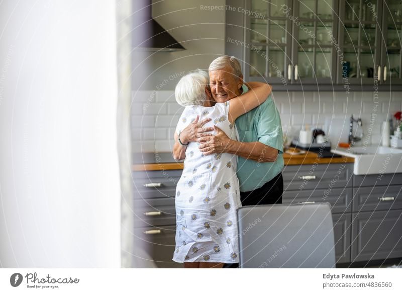 Älteres Ehepaar, das sich in der Küche umarmt älterer Erwachsener gealtert Porträt Person lässig Freizeit Lifestyle Rentnerin Kaukasier