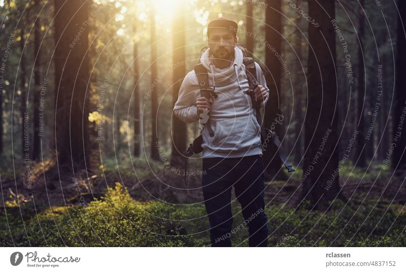 Porträt eines jungen Wanderers mit Rucksack im Wald an einem Sommertag Natur Landschaft Frühling Sonne Sonnenlicht Baum Nadelholz idyllisch Umwelt