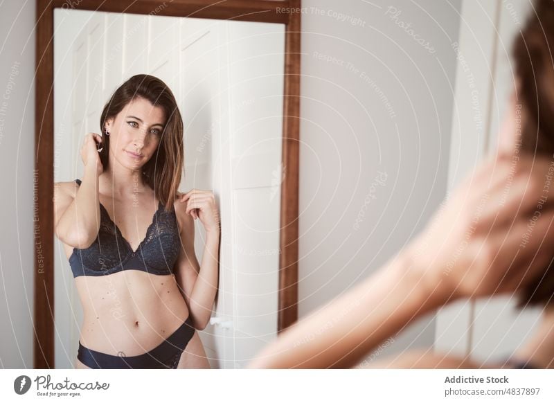 Verführerische Frau in Unterwäsche betrachtet ihr Spiegelbild Dessous sinnlich Verlockung verführerisch provokant Reflexion & Spiegelung berührende Haare sexy
