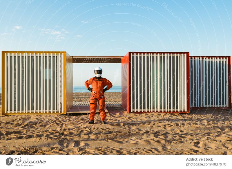Unbekannter Raumfahrer am Strand eines Außerirdischen Astronaut MEER bewundern Ausländer Gebäude futuristisch Konzept erkunden Raumanzug Sand Geometrie