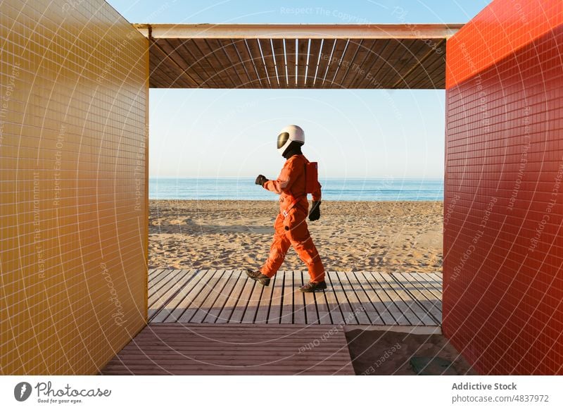 Unbekannter Raumfahrer am Strand eines Außerirdischen Astronaut MEER bewundern Ausländer Gebäude Architektur futuristisch Konzept erkunden Raumanzug Sand
