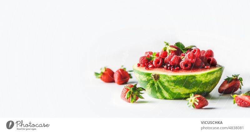 Banner mit Wassermelone halb gefüllt mit Erdbeeren und Himbeeren auf weißem Hintergrund. Transparente rot Frucht Hälfte erdbeeren weißer Hintergrund Gesundheit