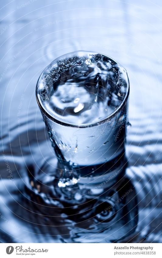 Blaues monochromes Bild von plätscherndem Wasser in einem Glas. platschen Monochrom aqua Hintergrund Getränk schwarz blau Unschärfe verschwommen Schaumblase