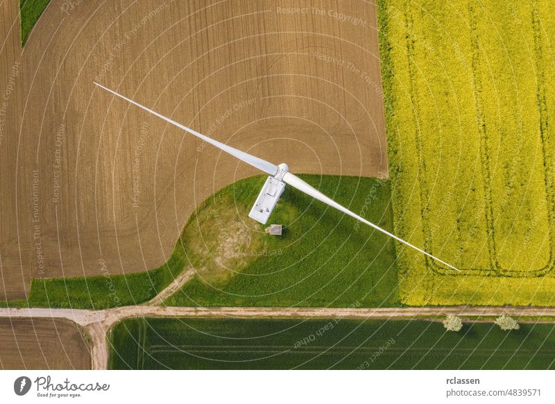 Windräder und landwirtschaftliche Felder an einem Sommertag - Energieerzeugung mit sauberer und erneuerbarer Energie - Draufsicht Turbine Kraft Windmühle Raster