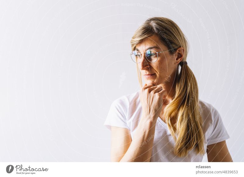Porträt einer jungen, nachdenklichen Frau, die ihre linke Hand auf das Kinn legt und positiv denkt, mit Platz für Text Denken Business Person Geschäftsfrau