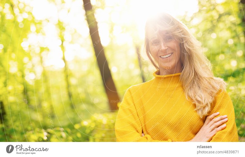 Nahaufnahme einer schönen Frau mit langen blonden Haaren an einem sonnigen Tag in der Natur, mit Platz für individuellen Text Erwachsener attraktiv
