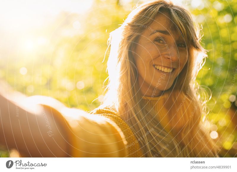 Close up Porträt der schönen Frau mit langen blonden Haaren, wobei selfie mit smartühone am sonnigen Tag in der Natur Selfie Erwachsener attraktiv