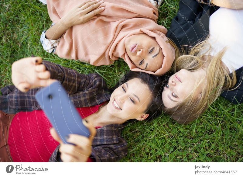Multirassische Freundinnen liegen im Kreis und machen ein Selfie Frauen bester Freund benutzend Freundschaft Smartphone Gedächtnis positiv Einheit einfangen