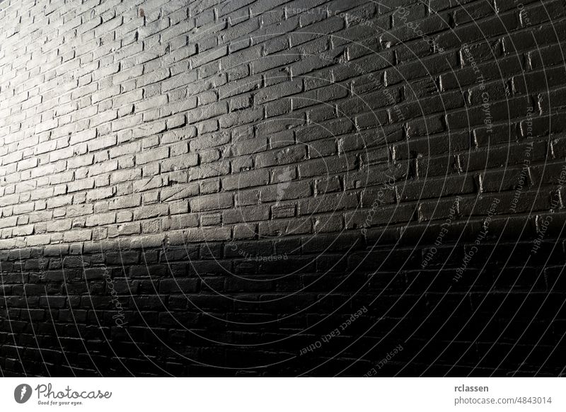 schwarz gestrichene Ziegelwand mit Sonnenlicht Baustein Wand Textur Licht abstrakt gealtert Architektur Hintergrund Klotz Mauerwerk erbaut Zement Großstadt Ton