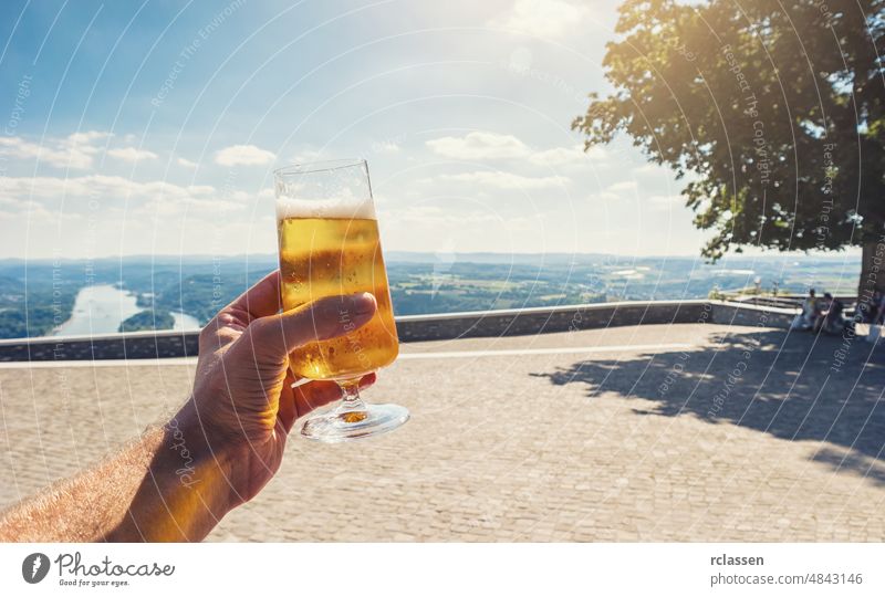 junger Mann trinkt frisches Bier in einem Biergarten im Sommer reisen trinken stupsen Bäume hell sonnig Restaurant Deutschland München Halt Tradition Vergnügen