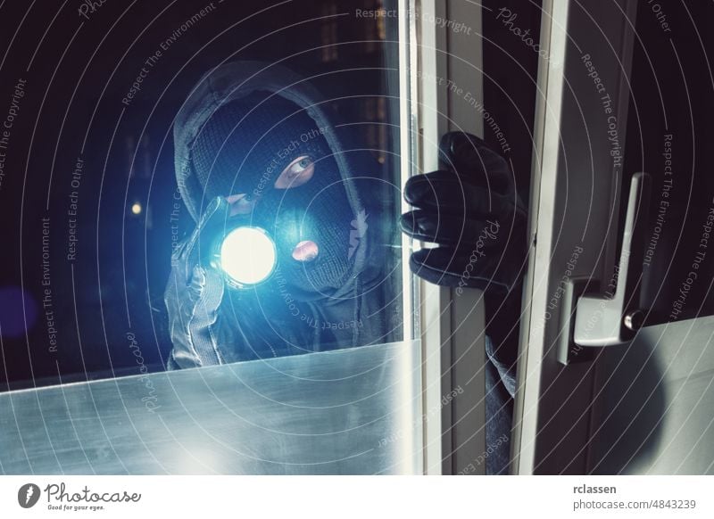 Einbrecher leuchtet nachts mit Taschenlampe in ein Haus Polizei Appartement stehlen weiß Überfall Werkzeug Hauseinbrecher Konzept Pause ungesetzlich männlich