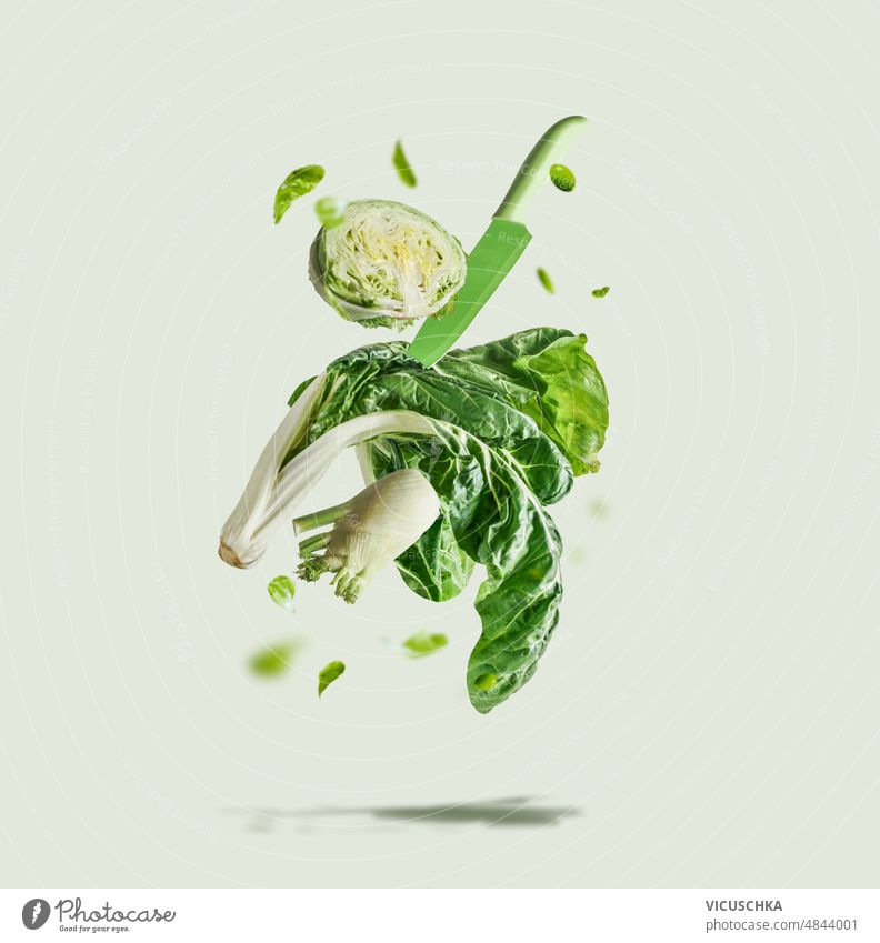 Fliegende grüne Gemüseauswahl mit Messer auf hellem Hintergrund. Zutaten für gesunde Ernährung fliegen Auswahl Licht Gesunde Ernährung Salat Fenchel Bok Choi