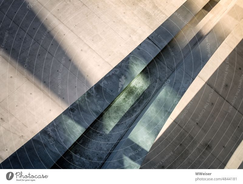 Ein rundes Betonelement mit Rinne bringt Abwechslung in die Architektur abstrakt Detai Kurve runden Element Berlin Regierungsviertel Licht Schatten grünlich