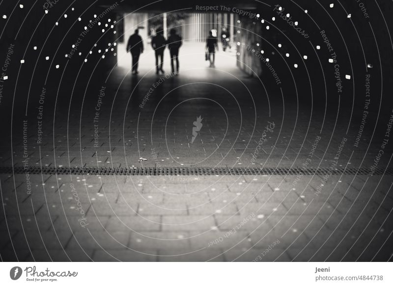 Menschen gehen durch die Unterführung Beleuchtung Tunnel Wege & Pfade Untergrund Fußgänger Silhouette Licht Schatten Symmetrie Durchgang dunkel Gegenlicht Gang