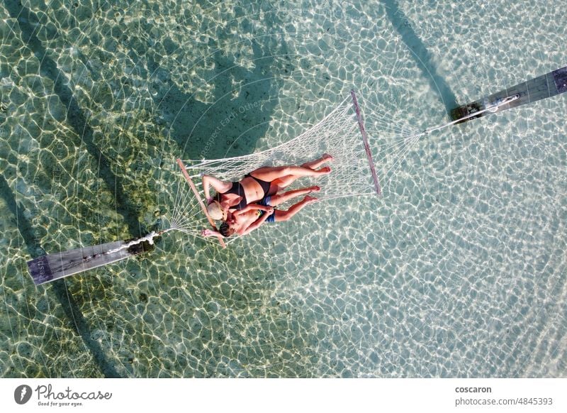 Mutter und Sohn entspannen sich in einer Hängematte über dem Wasser. Blick aus der Luft. Erwachsener Antenne Strand schön Kaukasier Kind Kindheit Küstenlinie