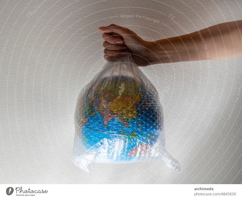 Hand hält einen in Plastik eingewickelten Globus Luftpolsterfolie Pflege Wandel & Veränderung Klima abschließen Konzept konzeptionell Erhaltung Erde Umwelt