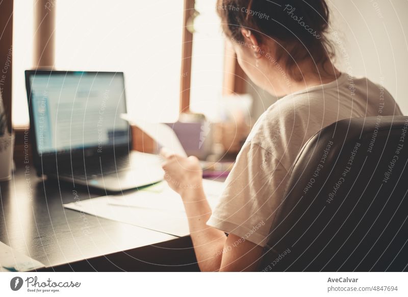 Zurück Bild einer jungen Frau studiert und arbeitet an seinem Schreibtisch zu Hause, Hausaufgaben während der Universität und freiberufliche Tätigkeiten arbeiten von zu Hause Konzept.