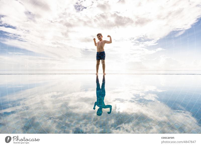 Kleines Kind am Rande eines Schwimmbeckens mit wolkigem Himmel im Hintergrund bezaubernd Bahamas Strandclub blauer Ozean Kaukasier heiter Kindheit Wolken