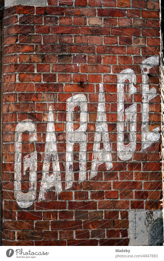 Alter verblichener weißer Schriftzug Garage in Versalien auf der alten rotbraunen Backsteinmauer einer Autowerkstatt in den Gassen der Altstadt von Brügge in Westflandern in Belgien