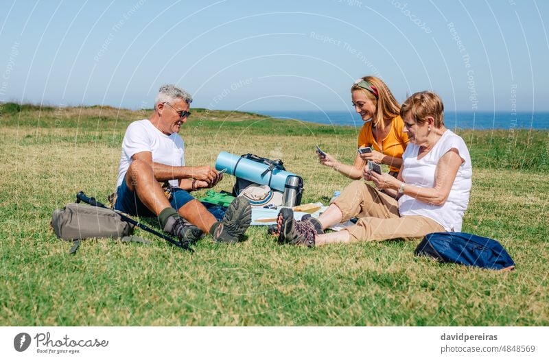 Erwachsene Familie beim Kartenspielen auf einer Decke sitzend während eines Ausflugs Erwachsener Postkarte Zusammensein Sitzen Senior Tochter Lächeln Eltern