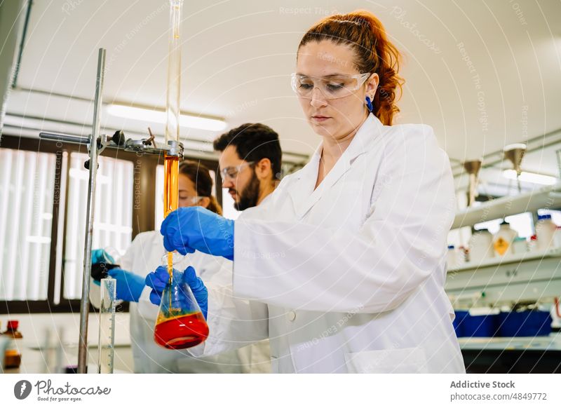 Wissenschaftler bereiten chemische Flüssigkeit im Labor vor forschen liquide eingießen Kollege Chemikalie wissenschaftlich Chemiker Experiment Probe Teamwork
