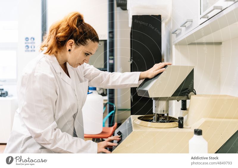 Konzentrierte Wissenschaftlerin, die moderne Geräte im Labor aufstellt Frau einrichten arbeiten Chemiker Maschine Kontrolle Vorrichtung Diagnostik Arbeit Fokus