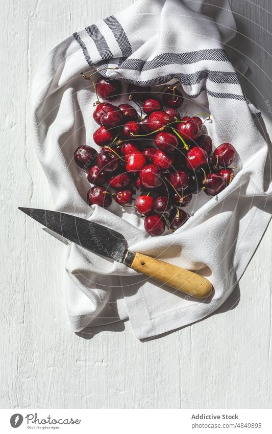 Kirschen auf Küchentuch auf weißem Hintergrund Frucht frisch Lebensmittel Beeren organisch reif rot Stoff Tisch natürlich lecker Messer geschmackvoll Gesundheit