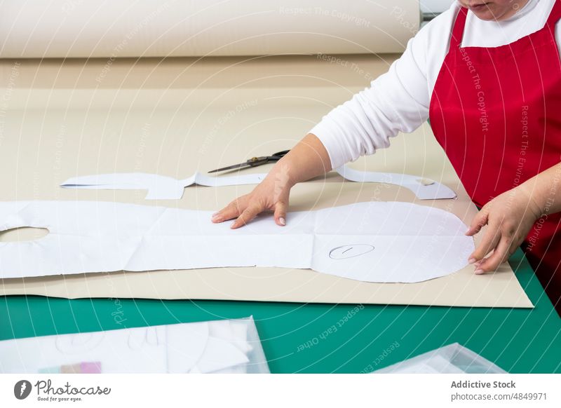 Unbekannte Näherin bei der Arbeit mit Papiermustern im Atelier Muster Textil Werkstatt Gewebe Damenschneiderin Vorrat Herstellung Industrie Vorrichtung