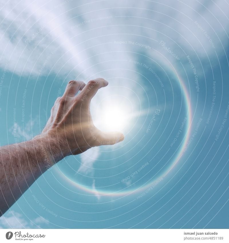 Mann Hand un in der Luft spielen mit dem Sonnenlicht Arme Finger Haut Handfläche Körperteil Wolken Himmel blau berührend Gefühl erreichend Zeigen Erreichen