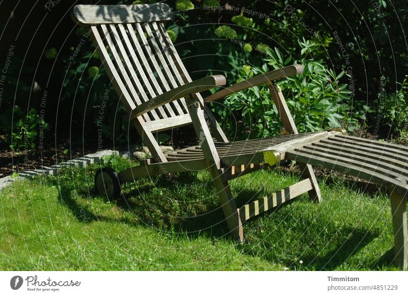 Mit Kinderaugen gesehen: eine Ruhemöglichkeit im Garten Deckchair Liegestuhl Holz Gras grün Pflanzen Gebüsch Licht Schatten Außenaufnahme Erholung Menschenleer