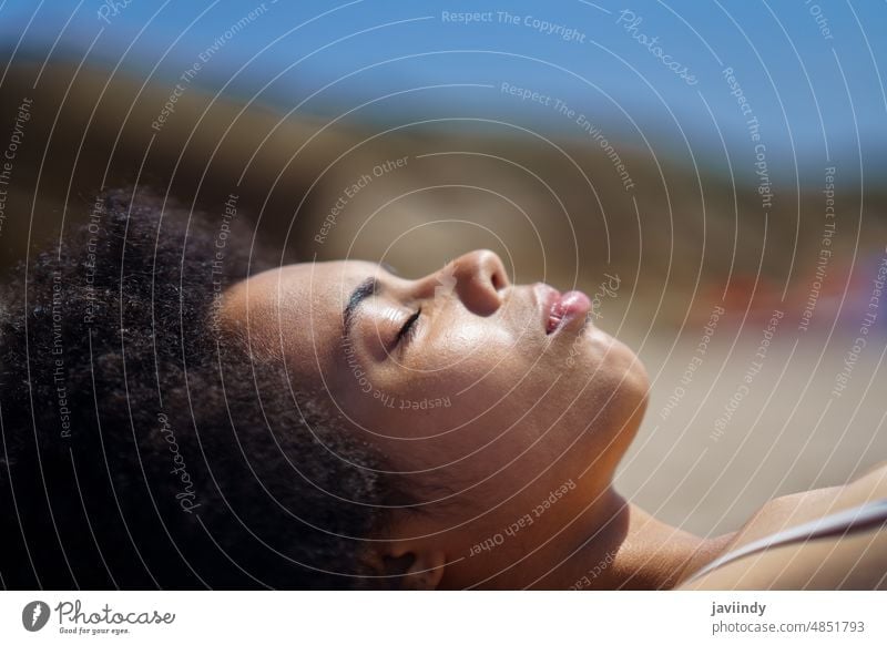 Junge afroamerikanische Frau am Strand liegend mit geschlossenen Augen Sonnenbad Sommer Urlaub Feiertag Augen geschlossen sich[Akk] entspannen Tourist friedlich