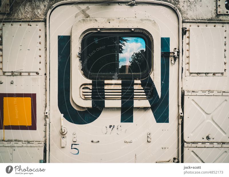 Aufschrift UN auf einem Container Metall Typographie Tür Schriftzeichen Fenster Reflexion & Spiegelung Abkürzung Großbuchstabe Detailaufnahme Luftschlitze