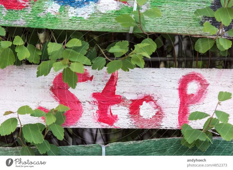 Ein gemalter Anschlag auf einem Holzbrett abstrakt gegen Aggression Aufmerksamkeit Hintergrund Unschärfe farbenfroh Mitteilung Konzept Konflikt Krise Gefahr