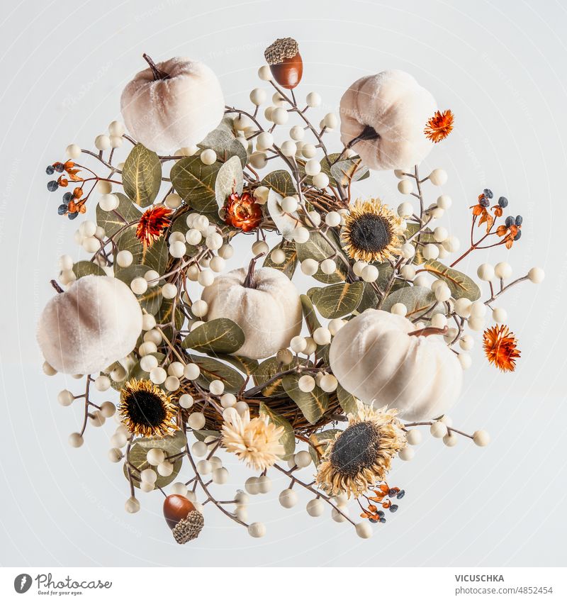 Komposition mit fliegenden Herbstkranz, weiße Kürbisse, getrocknete Blumen und Blätter auf weißem Hintergrund. Zusammensetzung Totenkranz Trockenblumen
