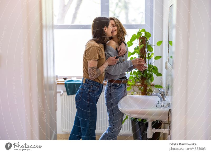 Lesbisches Paar küsst sich im Badezimmer ihrer Wohnung gleichgeschlechtliches Paar Erwachsener Appartement attraktiv schön Bonden Dating-Paar Genuss Familie