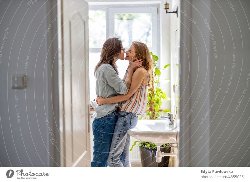Lesbisches Paar küsst sich im Badezimmer ihrer Wohnung gleichgeschlechtliches Paar Erwachsener Appartement attraktiv schön Bonden Dating-Paar Genuss Familie