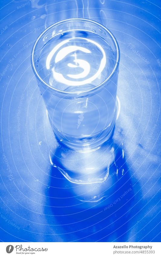 Glas mit kaltem Wasser in blauem Monochrom. abstrakt Stillleben Minimalismus aqua Hintergrund Getränk schwarz Unschärfe verschwommen Schaumblase Sauberkeit