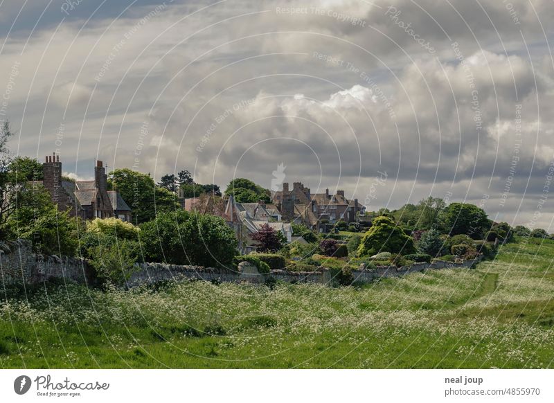 Dramatischer Wolkenhimmel über einem malerischen schottischen Dörfchens Landschaft Natur Dorf Schottland Hügel grau grün Wetter dramatisch dunkel Gewitter