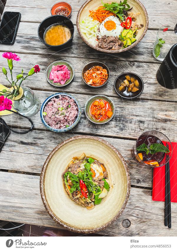 Bibimbap und Bulgogi - Farbenfrohes Koreanisches Essen auf einem Tisch Restsurant asiatisch Mahlzeit lecker bunt Stäbchen Schüsseln Teller bulgogi farbenfroh