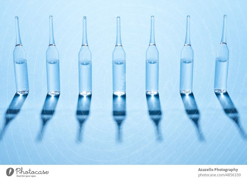 In einer Reihe stehende Ampeln auf blauem Hintergrund. Medizin Wissenschaft Ampulle Minimalismus Business Pflege Klinik abschließen Konzept Korona Coronavirus