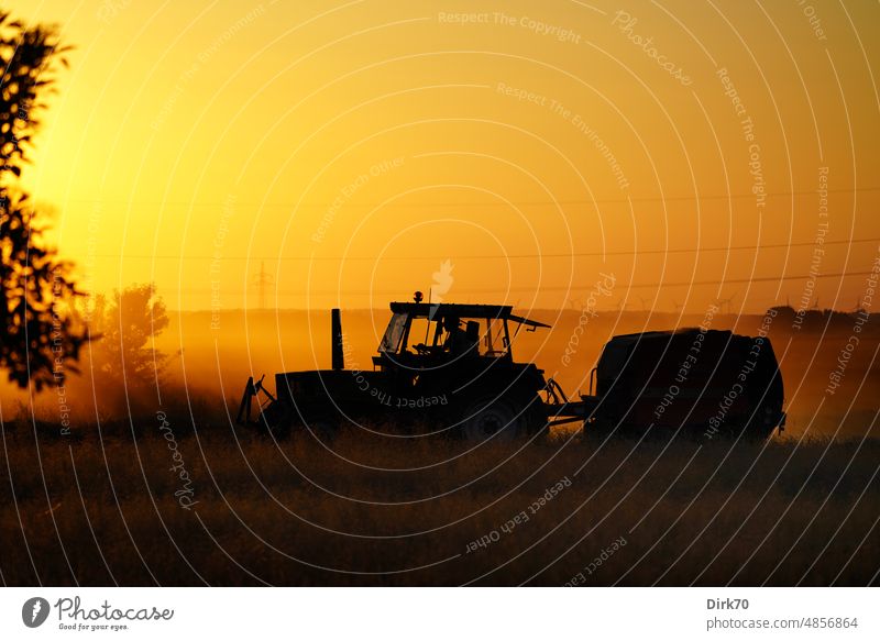 Heu machen - Traktor im Abendlicht trekker Trecker Licht Gegenlicht Abenddämmerung Dämmerung Landwirtschaft landwirtschaftlich Landwirtschaftliche Geräte Feld