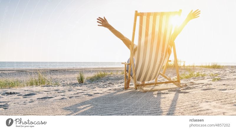 glückliche junge Frau im Liegestuhl sitzend am Sommerstrand, Platz für Ihren individuellen Text, Bannergröße Strand Stuhl Fröhlichkeit Gefühl Sonnenuntergang